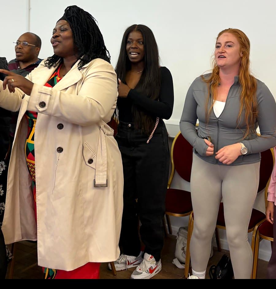 Members of GTIM standing and worshipping together during a Sunday service
