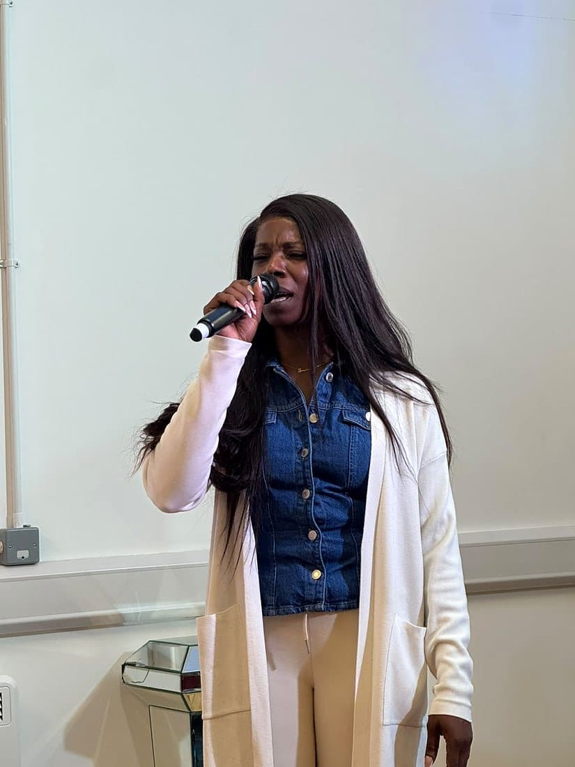 A woman singing a solo with eyes closed